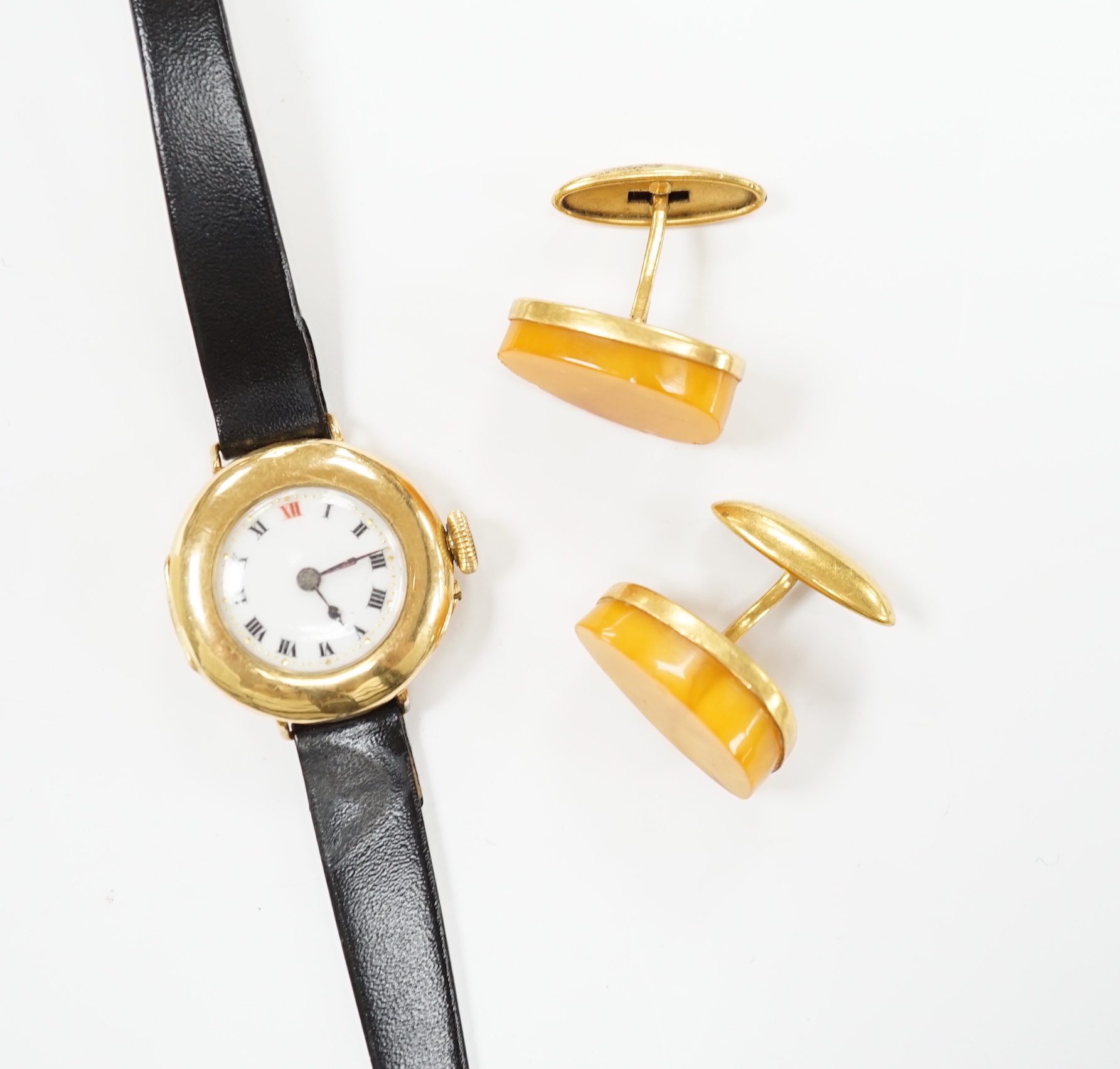 A lady's George V 18ct gold manual wind wrist watch, on later associated leather strap, case hallmarked for London, 1916, together with a pair of amber set gold plated cufflinks.